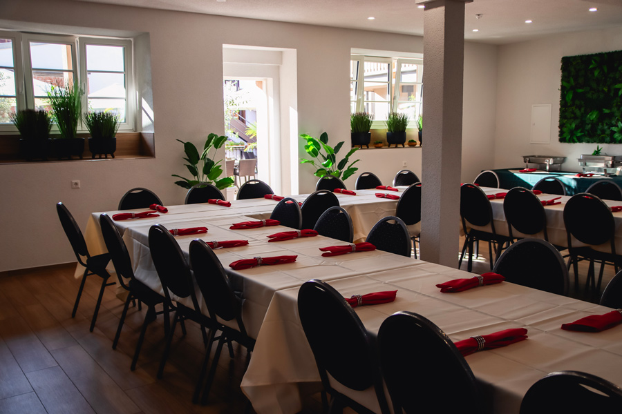 Großer Raum mit langer Tafel und Bepflanzung